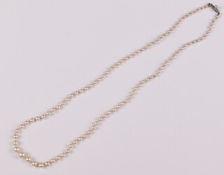 A string of cultured pearls with clasp marked 9K, 59cm 