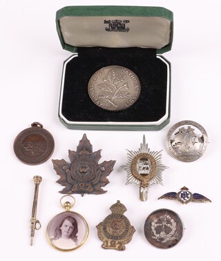 A silver National Trust medallion 25g, cased, a gilt metal double sided photographic locket and a small collection of cap badges 