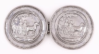 A circular embossed white metal belt buckle decorated a couple driving a horse and carriage 