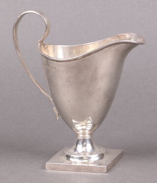 An Edwardian, Georgian style silver helmet shaped cream jug, raised on a square foot, Chester 1907 by John Milward Banks, 146g 