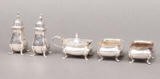 A 3 piece silver condiment set comprising 2 peppers and mustard pot, Birmingham 1915 (no liner to mustard, pepper are dented), together with a pair of silver salts Birmingham 1909 (no liners), 148g 