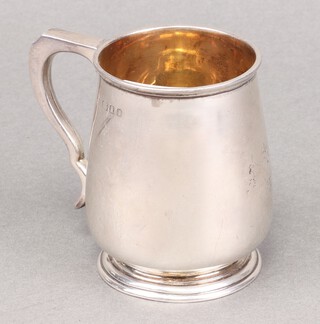 A plain silver christening tankard London 1934 by The Goldsmiths and Silversmiths Company, marks rubbed, 120g 