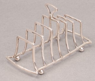 An Art Deco silver 7 bar toast rack, raised on bun feet, Birmingham 1931 by Henry Pidduck & Sons, 129g 
