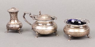 An Edwardian silver 3 piece condiment set with mustard, salt and pepper with blue glass liners (chipped), Sheffield 1907, by Henry Atkin, 202g 