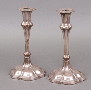 A pair of Rococo style silver plated candlesticks 23cm (plate worn in places) 