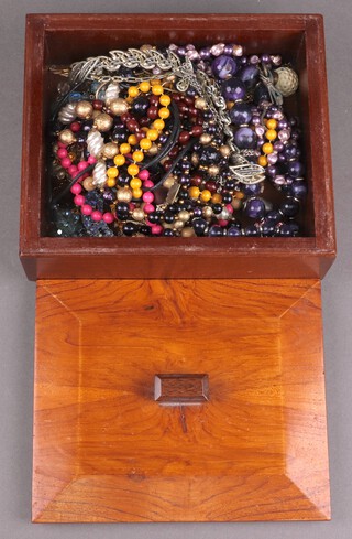 A quantity of costume jewellery contained in an Art Deco olive wood and mahogany box 