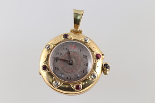 A yellow metal possibly of high carat circular watch pendant with gilt metal winder, the outer rim set rubies and diamonds (detached), the inner case engraved 17.01.39