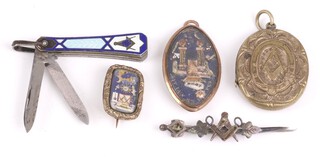 Masonic, an oval gilt metal brooch with paper decoration of columns, pyramid and coffin 3cm, 1 other decorated square, compass and radiant sun 2cm, an embossed gilt metal locket, a folding pocket knife with 3cm blade and nail file, enamelled grip decorated square and compass 4cm and a brooch (clasp a/f) 