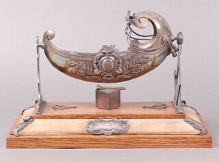 An Edwardian Masonic embossed silver model of a cradle, raised on square and compasses and a level, above perfect ashlar, raised on an oak base, having a presentation plaque "Lebanon Lodge no. 1326, presented to the wife of Brother Arthur Holland by the members of the lodge, to mark the happy event of the birth of a daughter, during his year of Office of Worshipful Master May 1902"  16cm h x 27cm w x 15cm d 