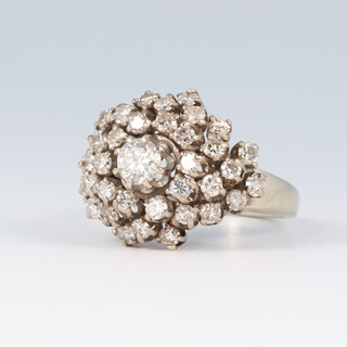 A white metal diamond set ring of cluster form, set numerous diamonds, the large central diamond approx. 0.3ct, size O 1/2