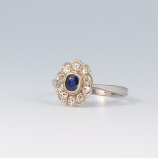 A platinum ring set a sapphire surrounded by diamonds size J, 2.9g