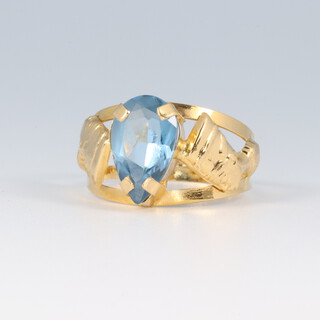 A yellow metal possibly high carat ring with pharaoh's heads to the shoulders, set a blue stone, size P, 2.4g