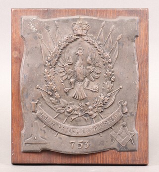 A Masonic embossed plaque marked Prince Frederick William Lodge 753, decorated an eagle within laurel wreaths, level, square and compasses, on an oak plaque 23cm h x 20cm w 