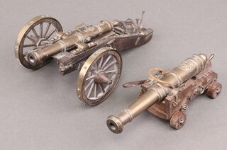 A brass table cannon in the form of a 17th Century cannon 16cm and 1 other with wooden carriage 
