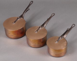 Three copper saucepans with lids and polished steel handles, 22cm, 21cm and 19cm 