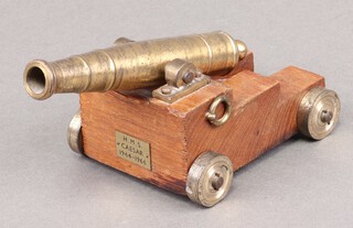 A brass table cannon with 15cm barrel on a wooden carriage marked HMS Caesar 1944-1966 