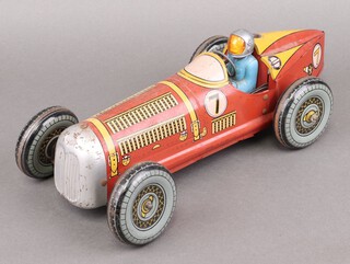 A Mettoy giant tinplate clockwork racing car with yellow, red and black lithographic detailing,  number 7 to bonnet and tail, moving steering wheel, blue driver with silver helmet (head detached), circa 1950's, 37cm long 