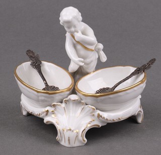 A 19th century KPM Continental porcelain double table salt decorated a seated cherub, the base marked KPM 10cm, together with a pair of 925 silver salt spoons marked Christoph Widmann 