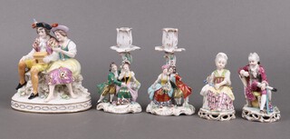 A pair of Sitzendorf porcelain candlesticks supported by lady and gentleman 14cm (1 arm a/f, flowers chipped in places) together with a pair of porcelain figures of a seated lady (foot chipped) and gentleman and 1 other of a couple with bird cage (rubbing to gilding) 
