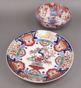 A Japanese Imari porcelain bowl with panel decoration 10cm h x 24cm diam. (chip to rim), together with an Imari charger decorated a vase of flowers, the base with signature 39cm diam. 