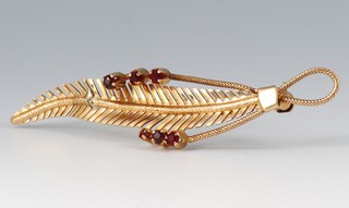A gold marked 750 leaf shaped brooch set red stones 6cm, 4.5g gross