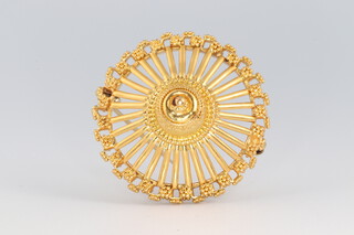 A yellow metal possibly high carat brooch of circular shape and spoked decoration, raised to the centre, 3.3cm diam. 12g