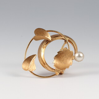 A yellow metal possibly high carat swirl brooch with leaf decoration, set a pearl 3cm wide, 3.5g