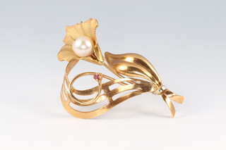 A gold marked 750 leaf and flower head shaped brooch, set a ruby and pearl, 5cm wide, 7.7g