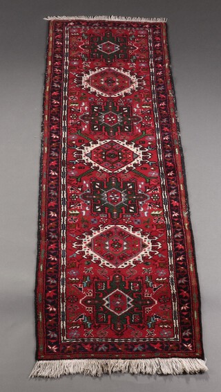 A red, green and blue ground Afghan runner with 7 stylised medallions to the centre within a 3 row border, 196cm x 64cm 