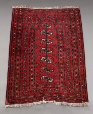 A red and blue ground Bukhara prayer rug with 7 octagons to the centre within a multi row border 130cm x 78cm 