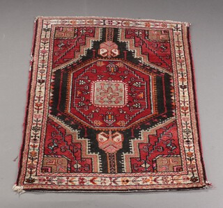 A red and black ground Afghan rug with central medallion 111cm x 83cm 