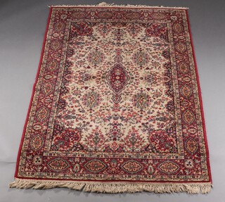 A red, green and cream patterned Persian style rug with central medallion 200cm x 141cm 