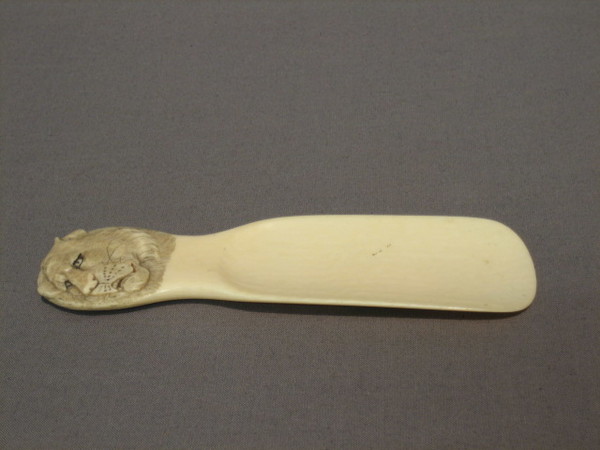 A carved ivory shoe horn the handle 